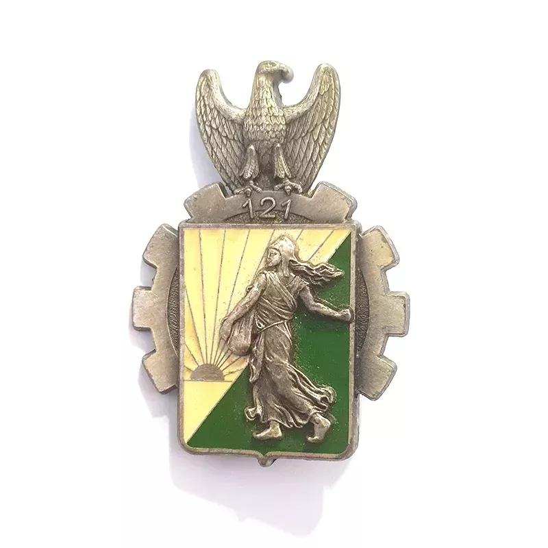 Insigne militaire du 121e régiment du Train, décoré d'un aigle, d'une roue, de la semeuse d’Oscar Roty devant le soleil.