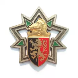 Insigne en forme d'étoile à 5 branches avec un cheval en or, un bouclier rouge et noir.