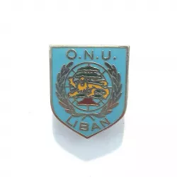 Bouclier bleu avec inscriptions "O.N.U.", "Liban" et l'illustration d'un globe, le cèdre du Liban, d'une couronne et d'un lion