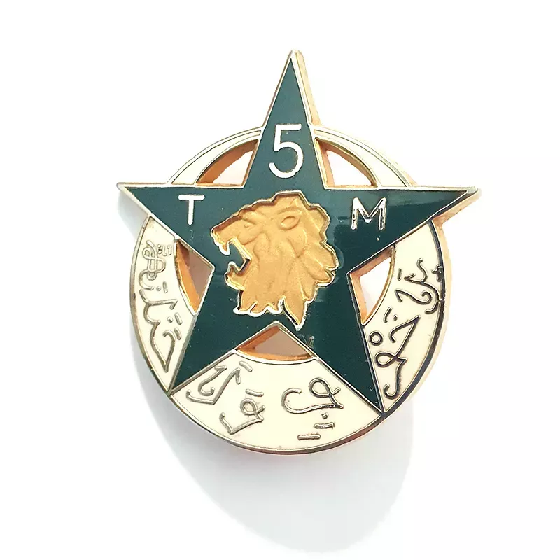 Insigne en forme d'étoile et de lune, représente une tête de lion accompagné d'écritures arabes et du titre "5TM".
