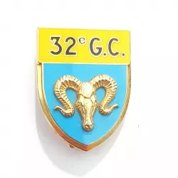 Insigne en forme d'écu, en or, jaune et bleu clair, représentant une tête d'un bélier en relief et marqué "32E G.C.".