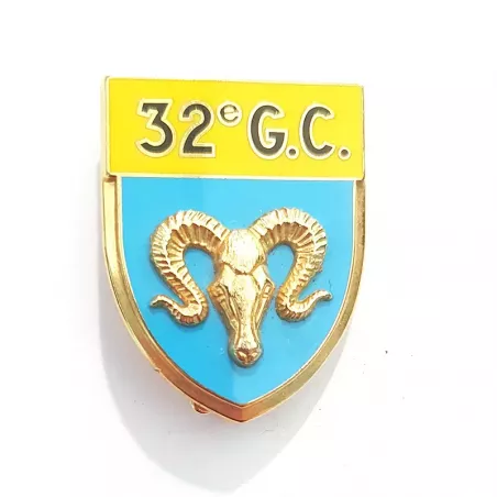 Insigne en forme d'écu, en or, jaune et bleu clair, représentant une tête d'un bélier en relief et marqué "32E G.C.".