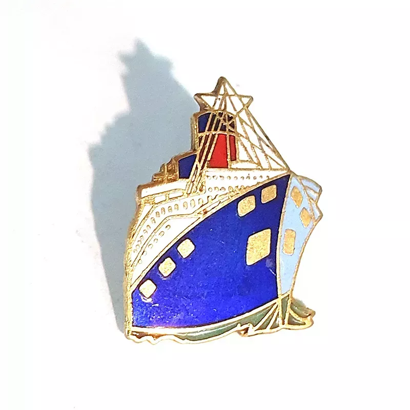 Pin's représentant un paquebot de couleur bleu, blanc et rouge, avec bordures dorées.