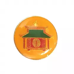 Pin's rond représentant une pagode aux couleurs rouge, vert et or, placé sur un fond orange.