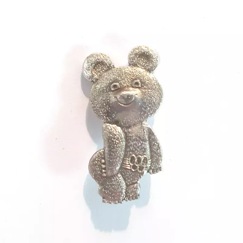 Broche couleur argent représentant l'ours Misha, la mascotte des jeux olympiques de Moscou.