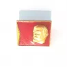 Pin's rectangulaire, orientation paysage, illustré avec la tête de Lénine couleur or et en relief sur un fond rouge.