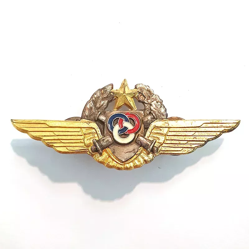 Brevet Observateur Moniteur Pilote de l'ALAT, représentant un écu, 2 canons, 3 anneaux noués une couronne et une paire d'ailes.